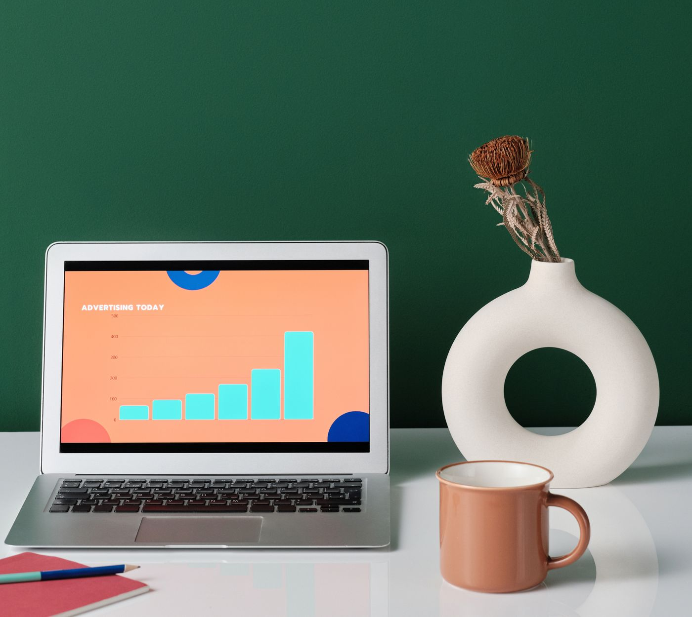 Laptop cu grafic si decor profesional pe fundal verde